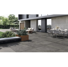 Dalle de terrasse moderne en grès cérame sur une vaste terrasse extérieure avec mobilier de jardin devant une maison moderne.
