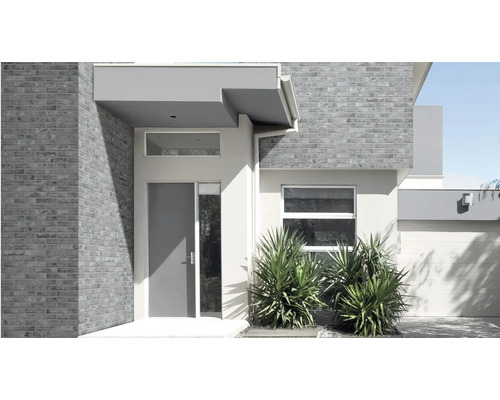 Moderner Hauseingang mit Ziegelmauerwerk und moderner Eingangstür in einem hellen und schlichten Design.