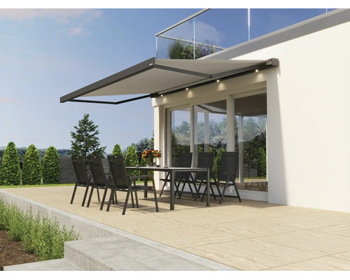 Store de terrasse moderne avec éclairage LED intégré au-dessus d'un salon de jardin sur une terrasse devant une maison moderne.