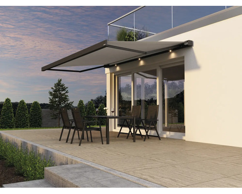 Store de terrasse moderne avec éclairage LED intégré au-dessus d une terrasse avec salon de jardin devant une maison moderne.