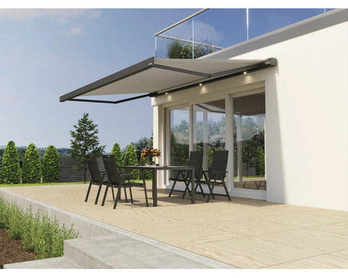 Store banne moderne avec éclairage LED intégré monté sur une façade au-dessus d une terrasse avec salon de jardin