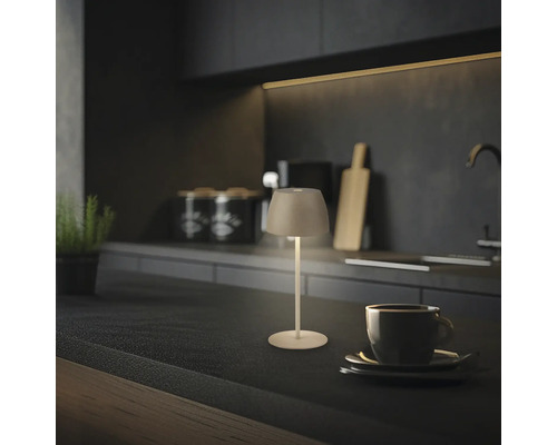 Lampe de table LED sans fil moderne sur un plan de travail de cuisine sombre, éclairage d accentuation chaleureux pour intérieur.