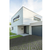 Modernes zweistöckiges Wohnhaus mit quadratischen Rasengittersteinen in der Einfahrt und angrenzender Garage.