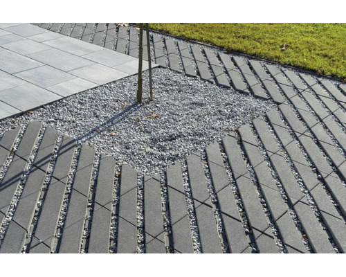 Gartenweg aus Betonpflastersteinen in Gitteroptik mit Schotterbett und angrenzendem Rasen sowie Terrassenplatten.