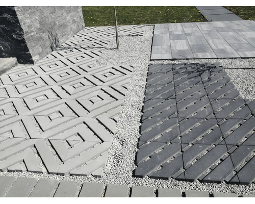 Verschiedene Terrassenplatten und Pflastersteine in einem Außenbereich mit Kiesbett und Mauerwerk