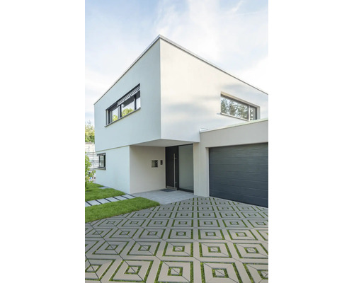 Modernes zweistöckiges Wohnhaus mit flachem Dach, integrierter Garage und gepflasterter Zufahrt mit Rasenfugen.