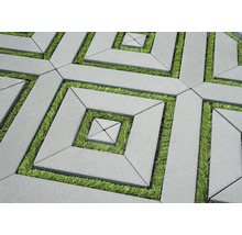 Geometrisches Pflaster aus Beton mit Rasenfugen in einem quadratischen Muster.