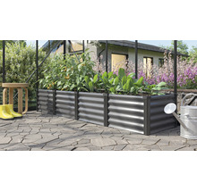 Jardinière surélevée rectangulaire en métal dans une serre, plantée de tomates et de laitue sur une terrasse pavée dans le jardin.