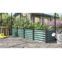Rechteckiges Hochbeet aus Metall mit Wellenstruktur in einem Gewächshaus mit Pflanzen und Gartenutensilien