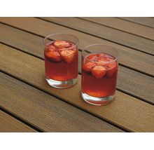 Deux verres remplis de boisson à la fraise sur une terrasse en bois.