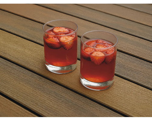 Deux verres remplis de boisson à la fraise sur une terrasse en bois.