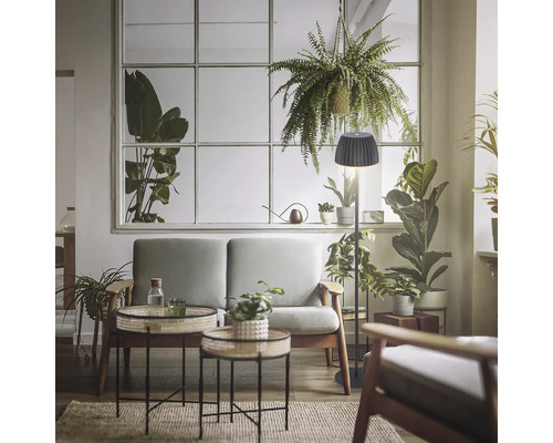 Lampadaire moderne avec abat-jour plissé dans un salon lumineux et accueillant, agrémenté de plantes d'intérieur et de meubles rembourrés.