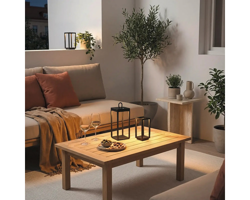 Moderne Balkongestaltung mit gemütlichem Lounge Sofa Holztisch und dekorativen LED Laternen für eine einladende Atmosphäre am Abend