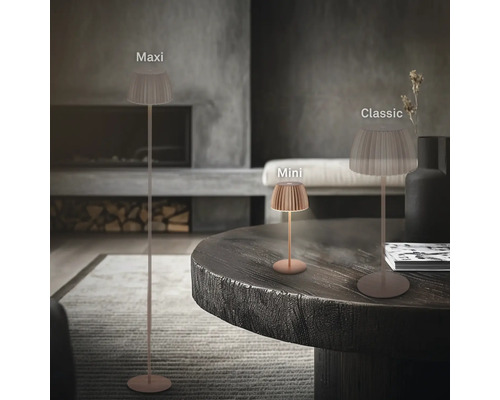 Drei moderne LED Leuchten in den Varianten Maxi als Stehleuchte sowie Mini und Classic als Tischleuchten in einem Wohnraum mit Kamin.