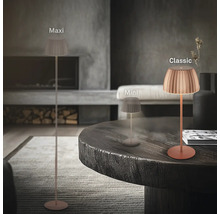 Drei verschiedene Grössen der LED Tisch und Stehleuchte mit plissiertem Schirm in einem modern eingerichteten Wohnzimmer mit Kamin.