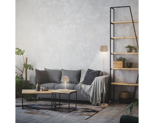 Salon moderne avec lampadaire et lampe de table avec abat-jour plissé près d'un canapé gris.