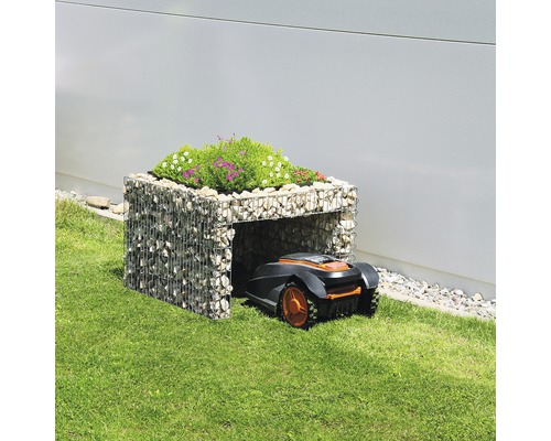 Robot tondeuse dans un garage en gabion avec des plantes sur le toit