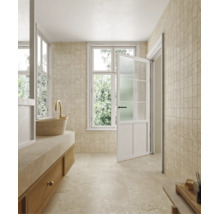 Badezimmer mit beigen Fliesen in Steinoptik, Waschtisch mit Aufsatzwaschbecken und Fenster.