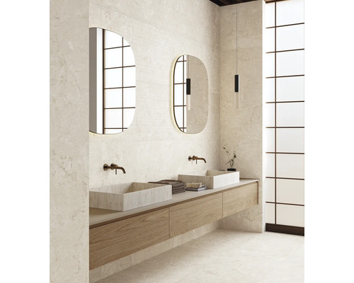 Salle de bains moderne avec deux vasques, meuble sous vasque suspendu en bois, miroirs ovales et carrelage aspect pierre naturelle.