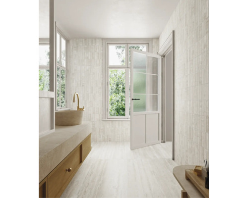 Salle de bains lumineuse au design moderne avec carrelage mural et au sol aspect pierre naturelle, meuble vasque en bois et porte-fenêtre.