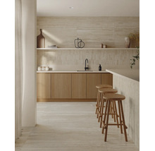 Cuisine moderne avec façades en bois, carrelages en pierre naturelle au mur et au sol, plan de travail et trois tabourets de bar.