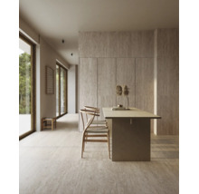 Modernes Esszimmer mit Natursteinoptik Fliesen an Boden und Wand, Holztisch und zwei Stühlen in einem lichtdurchfluteten Wohnbereich.
