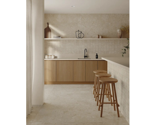 Cuisine moderne avec façades en bois, crédence carrelée, sol en pierre, étagère ouverte et trois tabourets de bar dans une ambiance lumineuse.