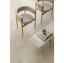 Sol carrelé clair aspect pierre naturelle dans un espace de vie minimaliste avec deux chaises et une petite table.