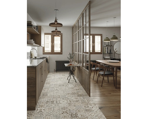 Moderne Wohnküche mit gemusterten Fliesenboden, Holzfronten und einer gläsernen Raumtrennwand zwischen Kochbereich und Esszimmer mit Holztisch.