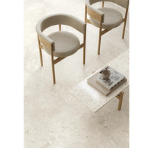Espace de vie avec chaises modernes en bois et table basse sur carrelage grand format aspect pierre naturelle dans une ambiance minimaliste.