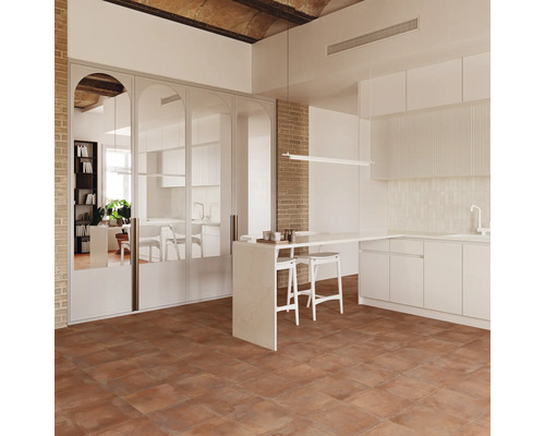 Cuisine moderne avec carrelage carré aspect pierre, murs en briques et hautes portes miroir arquées, design intérieur ouvert.