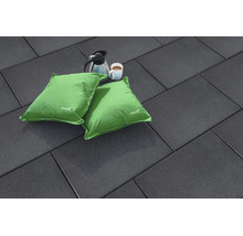 Dunkle Terrassenplatten in Rechteckform mit zwei grünen Sitzkissen, einer Kaffeekanne und einer Kaffeetasse auf einer ebenen Bodenfläche.