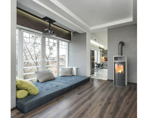 Séjour moderne avec poêle, grande baie vitrée avec espace salon et vue sur la cuisine attenante.