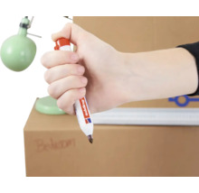Hand hält einen Edding Permanentmarker zum Beschriften eines Kartons