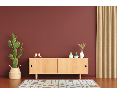 Wohnzimmer mit hellem Holz Sideboard vor einer Wand, dekoriert mit Kaktee, kleinen Vogelstatuen, Vasen und einem Teppich.