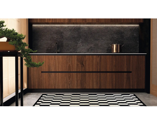 Moderne Kuche mit Holzfronten, dunkler Steinruckwand, Armatur und Kochtopf sowie einem grafisch gemusterten Teppich auf dem Boden.