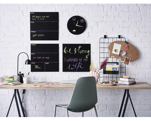 Bureau à domicile moderne avec tableaux muraux, tableau en liège, horloge murale et bureau devant un mur en briques blanches.