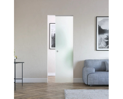 Porte coulissante tout en verre satiné avec poignée encastrée dans un salon lumineux avec canapé et parquet.