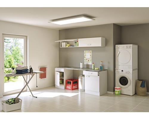 Buanderie claire avec lave-linge, sèche-linge, planche à repasser, armoires murales et éclairage