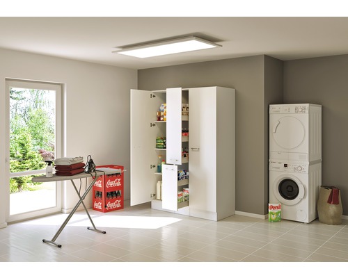 Buanderie lumineuse avec machine à laver, sèche-linge, planche à repasser et armoire haute avec étagères