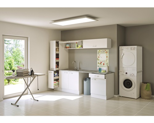 Buanderie lumineuse avec lave-linge, sèche-linge, lavabo, armoires et planche à repasser