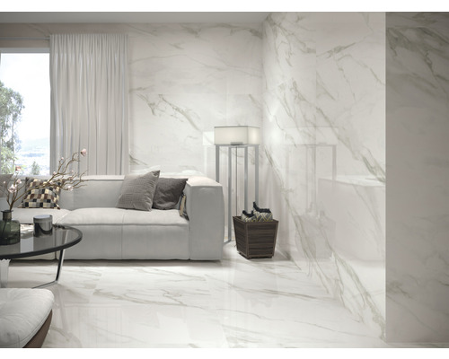 Salon lumineux avec carrelage au sol et mural aspect marbre, canapé et décoration