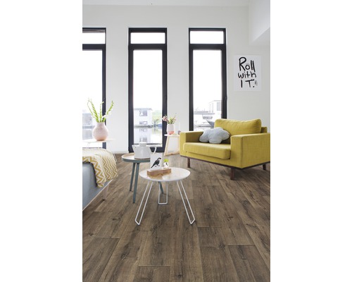 Wohnzimmer mit Laminatboden in Holzoptik, Sessel und Fenstern