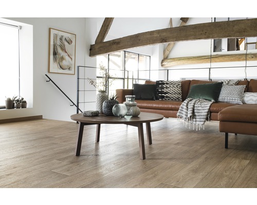 Wohnraum mit Holzbalkendecke, braunem Ledersofa und einem runden Couchtisch