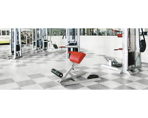 Salle de fitness avec appareils de sport et revêtement de sol à damier