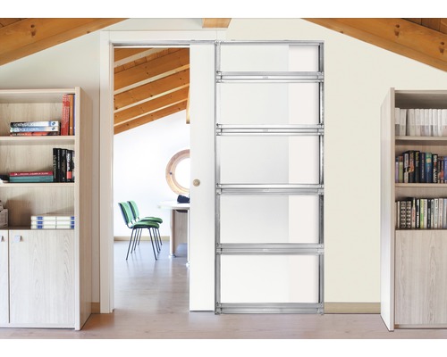 Intérieur moderne avec un système de porte coulissante en métal et verre donnant sur une pièce lumineuse avec des poutres en bois au plafond.