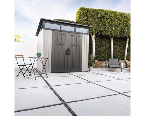 Scène de jardin avec remise, table de jardin et chaise sur une terrasse