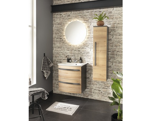 Badezimmer mit Waschtisch, Spiegelschrank und beleuchtetem Spiegel vor Steinwand