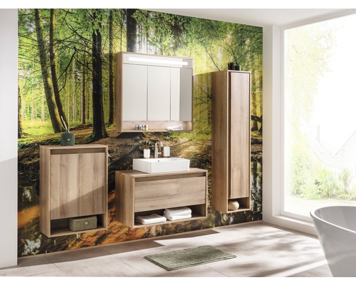 Badezimmer mit Waschtisch, Spiegelschrank und Hochschrank vor Waldtapete