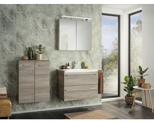 Helles Badezimmer mit Waschtisch, Spiegelschrank, Hängeschrank und Zimmerpflanzen vor einem Fenster